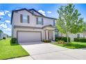 Attractive two-story home featuring a two-car garage, a red front door, and nice landscaping at 208 English Heritage Pl, Dover, FL 33527