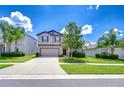 Beautiful two-story home with lush landscaping, a well-manicured lawn, and a spacious driveway at 208 English Heritage Pl, Dover, FL 33527