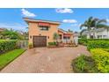 Charming home showcasing a red tile roof, awnings, a well-manicured lawn, and a brick-paved driveway at 243 Snell Isle Ne Blvd, St Petersburg, FL 33704