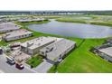 Aerial view of homes with well-maintained lawns and a scenic pond in a Primary-planned community at 271 Monet Trl, Bradenton, FL 34212