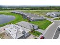 Aerial view showcasing homes in a suburban community, featuring manicured lawns and a serene lake at 271 Monet Trl, Bradenton, FL 34212
