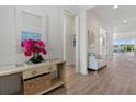 Inviting foyer with light wood floors, white walls, and a decorative console table with a large mirror at 271 Monet Trl, Bradenton, FL 34212
