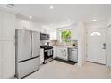 Bright kitchen with stainless steel appliances, white cabinets, and a window view at 3114 59Th S St # 101, Gulfport, FL 33707
