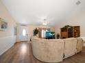 Inviting living room featuring wood flooring, a large sofa, and ample natural light at 3831 Yardley N Ave, St Petersburg, FL 33713