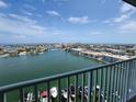 Waterfront view from a balcony featuring boats docked along the channel and buildings against a blue sky at 400 64Th Ave # 1105, St Pete Beach, FL 33706