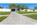 Charming single-story home features a driveway, well-manicured lawn, and a white fence surrounding the yard at 4111 Whiting Se Dr, St Petersburg, FL 33705