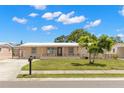 Street view of a single-story home with green lawn and covered entry at 4414 W Hanna Ave, Tampa, FL 33614