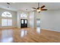 Bright and airy living room featuring hardwood floors, arched windows and a ceiling fan at 6123 India Dr, Spring Hill, FL 34608