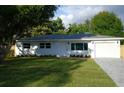 Beautifully renovated home with a lush lawn, fresh landscaping, and an attached garage at 6332 Emerson S Ave, St Petersburg, FL 33707