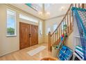 Bright foyer with a staircase, high ceilings, decorative lighting, wood floors and large double doors at 6543 Louise Ct, Hudson, FL 34667