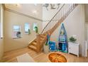 Light and airy foyer with wooden staircase, beach-themed decor, hardwood floors, and plenty of natural light at 6543 Louise Ct, Hudson, FL 34667