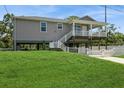 Inviting two-story home with a spacious covered porch and a well-manicured front lawn on a sunny day at 9107 Brunswick Ln, Tampa, FL 33615