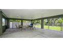 Spacious covered outdoor entertaining area with a ceiling fan and plenty of seating, perfect for gatherings at 9107 Brunswick Ln, Tampa, FL 33615