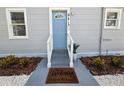 Charming home featuring a light blue front door, fresh landscaping, and a welcoming entrance at 921 Grand Central St, Clearwater, FL 33756