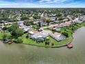 Waterfront home featuring a screened pool, a private dock and lush landscaping on a sunny day at 9619 Towanda Ln, Port Richey, FL 34668