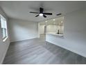 Open-concept living room featuring light gray flooring, neutral walls, and modern ceiling fan at 1005 S Empire St, Plant City, FL 33563