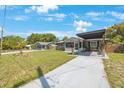 Single-story home with a well-maintained front yard and covered driveway that provides ample space for parking at 1010 E Fern St, Tampa, FL 33604