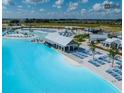 Expansive lagoon view with white sand beaches, club house, and rows of lounge chairs at 10747 Laxer Cay Loop, San Antonio, FL 33576