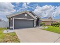Charming single-story home featuring a well-manicured lawn and a two-car garage with inviting curb appeal at 10915 Kirkwall Port Dr, Wimauma, FL 33598