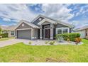 Charming single-story home featuring a well-manicured lawn and a two-car garage with inviting curb appeal at 10915 Kirkwall Port Dr, Wimauma, FL 33598