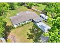 Aerial view of the property showcasing the house, a covered parking area, and large yard at 12631 Hobson Simmons Rd, Lithia, FL 33547