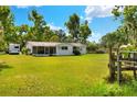 Back exterior showing a spacious yard, screened porch, and fenced area at 12631 Hobson Simmons Rd, Lithia, FL 33547
