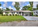 Charming single-story home featuring a large front yard, covered parking, and well-maintained lawn at 12631 Hobson Simmons Rd, Lithia, FL 33547