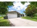 Inviting single-Gathering home with a two-car garage and a well-kept lawn, framed by lush, mature trees at 1461 S Hillcrest Ave, Clearwater, FL 33756