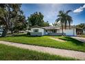 Landscaped front yard leading up to a charming single story home with a one-car garage at 2003 Whispering Pines St, Largo, FL 33774