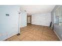 Spacious living room with light blue walls, white brick accent wall, and tile flooring at 2003 Whispering Pines St, Largo, FL 33774