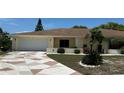 A single Gathering home featuring a patterned driveway, manicured lawn, and a two-car garage at 205 Strong Bow Ct, Sun City Center, FL 33573