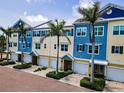 Beautiful townhome exterior with garages, lush tropical landscaping, and coastal architecture in Indian Rocks Beach, Florida at 208 Haven Beach Ct, Indian Rocks Beach, FL 33785
