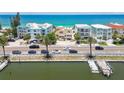Beautiful street view of beach homes with palm trees, parked cars, and waterfront access at 30 Gulf Blvd, Indian Rocks Beach, FL 33785
