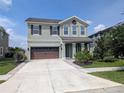 Inviting two-story home showcasing a spacious driveway, attached two-car garage, and well-maintained landscaping at 32599 Natural Bridge Rd, Wesley Chapel, FL 33543