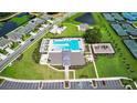 Aerial view of a community pool, playground, tennis courts, and surrounding houses and landscaping at 36618 Garden Wall Way, Zephyrhills, FL 33541