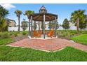 Community gazebo with Adirondack chairs on a brick patio with professional landscaping at 36618 Garden Wall Way, Zephyrhills, FL 33541