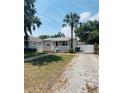 Charming one-story home with a welcoming front porch, palm tree, and ample parking space at 4111 W Grace St, Tampa, FL 33607