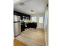 Modern kitchen with stainless steel appliances, dark cabinetry, granite countertops, and new flooring at 4111 W Grace St, Tampa, FL 33607