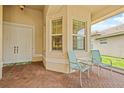 Inviting covered front porch with brick flooring, seating, and a double door entrance at 4911 Rock Island Ct, Wimauma, FL 33598