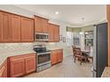 Well-equipped kitchen featuring wooden cabinets, stainless steel appliances, and granite countertops at 4911 Rock Island Ct, Wimauma, FL 33598