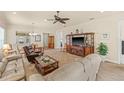 Open-concept living room with tile flooring, ceiling fan, and ample seating at 4911 Rock Island Ct, Wimauma, FL 33598