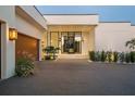 Modern home featuring a paver driveway, custom garage door, and manicured landscaping at 501 Barcelona Dr, Tierra Verde, FL 33715