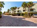 Exterior view of condo building with brick-paved parking and well-manicured landscaping at 505 Sandy Hook Rd # 505, Treasure Island, FL 33706