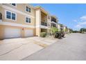 Three-story condo building with attached garages and balconies with well-maintained landscaping at 5065 Royal Palms Way # 303, New Port Richey, FL 34652