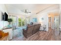 Bright living room with wood floors, ceiling fan, and sliding glass doors to a balcony at 5065 Royal Palms Way # 303, New Port Richey, FL 34652