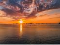 Golden sunset reflecting on the water with boats and buildings silhouetted against the colorful sky at 55 Rogers St # 502, Clearwater, FL 33756