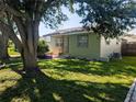 Exterior view of a cozy single-story home, featuring a green lawn and shade trees at 5725 18Th S Ave, Gulfport, FL 33707
