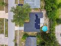 An aerial shot shows a home with solar panels, a refreshing pool, and mature trees in a residential neighborhood at 6200 13Th Ave, New Port Richey, FL 34653