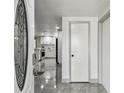 Foyer view showcases the home's interior with tile flooring, a kitchen with white cabinets, and stainless-steel appliances at 6200 13Th Ave, New Port Richey, FL 34653