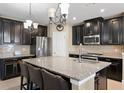 Modern kitchen with granite countertops, stainless steel appliances, and a large island with seating at 8636 Prairie Creek Dr, New Port Richey, FL 34655